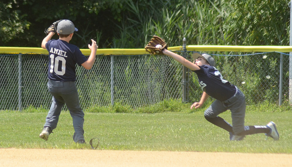 Pine Bush Rebels’ left fielder Carter Auryansen makes a diving catch on a popup in front of shortstop Connor Amiel during Saturday’s Greater Hudson Valley Baseball League 10U Division 3 playoff game at Pine Bush Town Park.